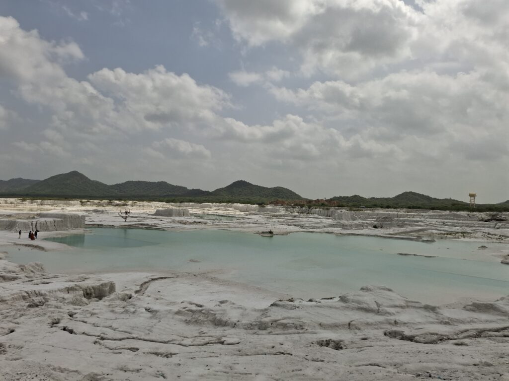 Turquoise pool between white ridges, with low hills on the horizon, Kishangarh, Rajasthan